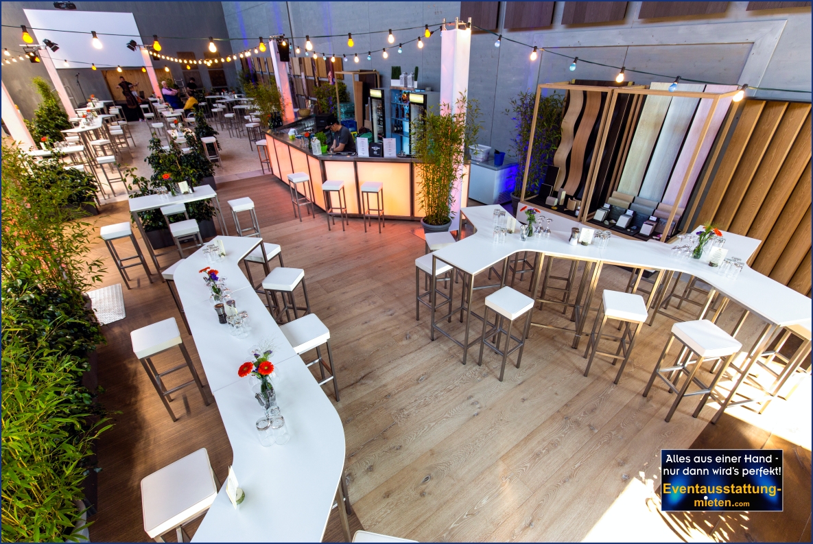 Wir gestalten Firmengebäude zur Eventlocation in Bayern Eventausstattung mit modernen weißen Stehtischen, LED-Bar, Pflanzen und Lichterketten für Firmenfest