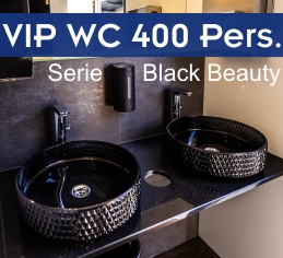 Exklusives Interieur eines VIP-Toilettenanhängers für Firmenevents: Zwei mattschwarze Designer-Aufsatzwaschbecken auf einer edlen Waschtischplatte mit modernen Armaturen und großen Spiegeln.